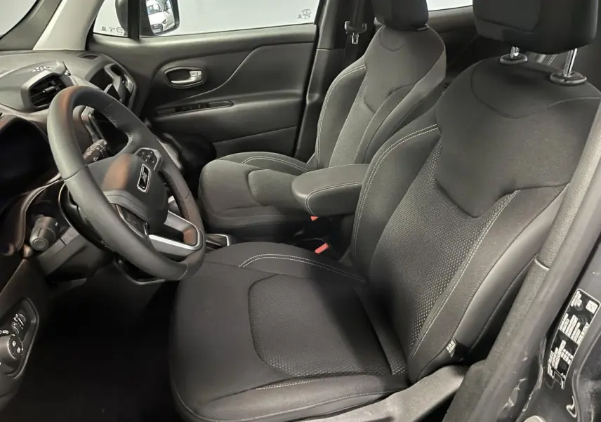 Intérieur du Jeep Renegade 2024, vue côté conducteur, sièges tissu noir avec surpiqûres grises et volant multifonction.