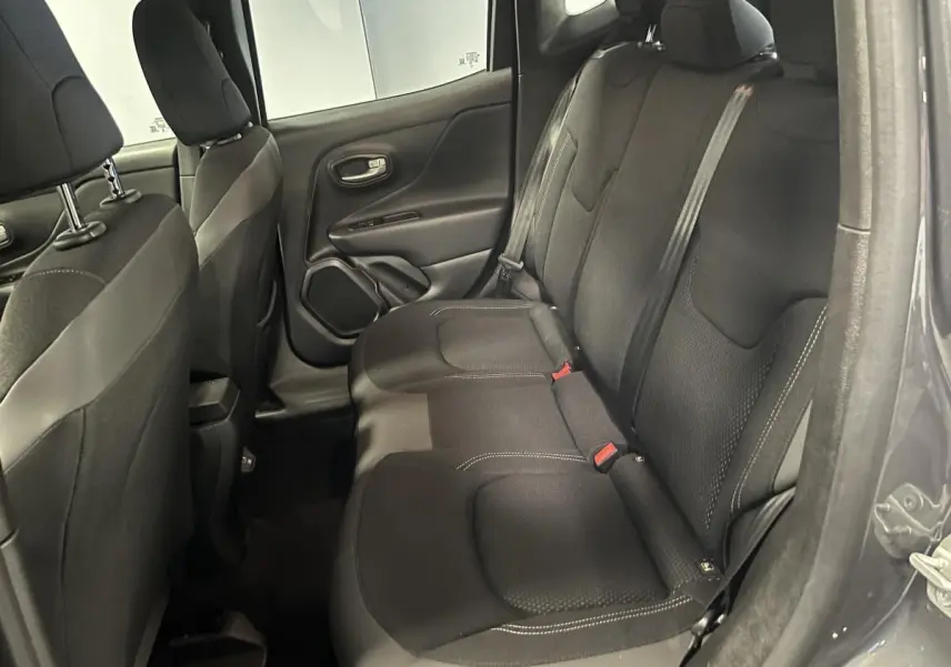 Vue intérieure côté droit des sièges arrière en tissu noir du Jeep Renegade gris 2024, avec ceintures de sécurité visibles.