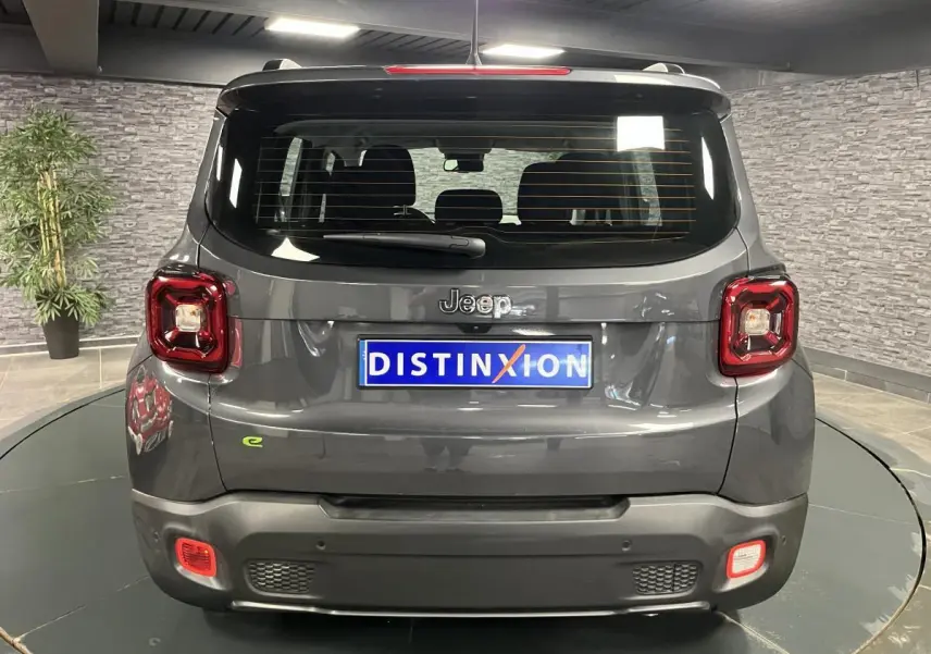 Vue arrière d'un Jeep Renegade gris métallisé avec feux carrés et logo e-Hybride vert sur le coffre