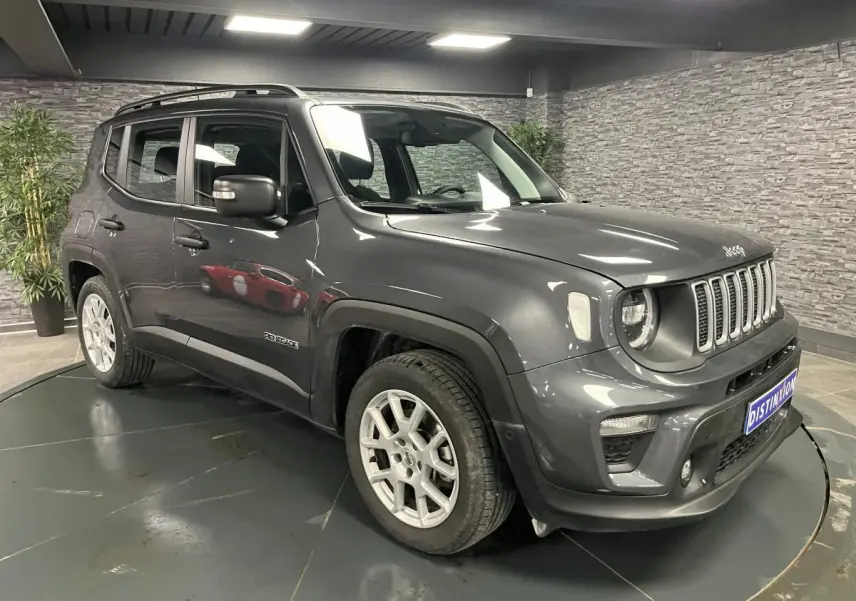 Jeep Renegade gris métallisé en 3/4 avant droit, avec calandre noir mat et jantes alliage 17 pouces visibles.