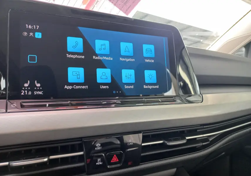 Écran tactile central affichant les menus multimédia et climatisation dans le tableau de bord d'une Volkswagen Golf 2023.