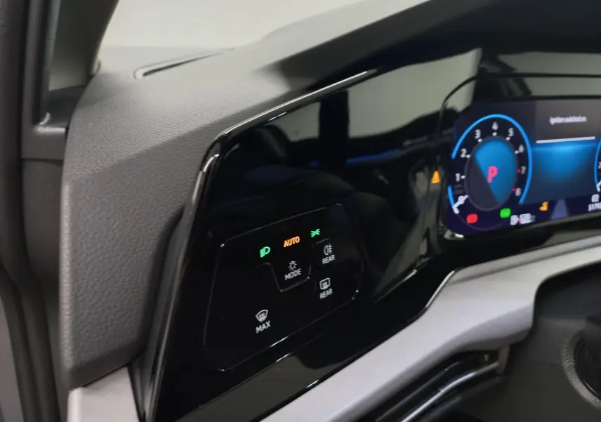 Détail du tableau de bord numérique et commandes d'éclairage d'une Volkswagen Golf gris dauphin, version 2023.