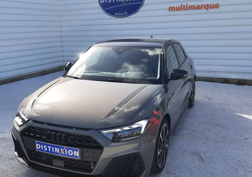 Audi A1 Sportback 2025 gris Chronos avec toit noir, vue 3/4 avant droit, jantes alu 18 pouces hélice et vitres surteintées.