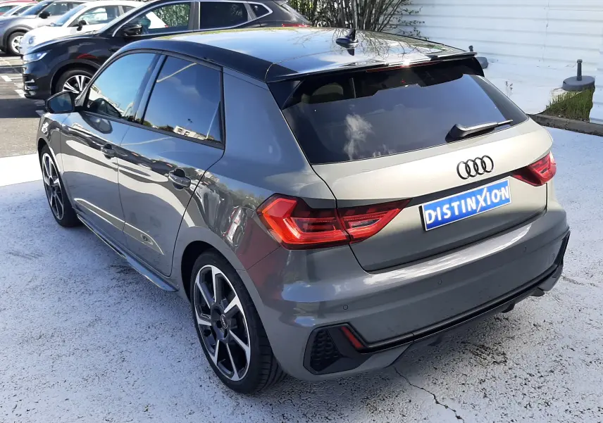 Audi A1 Sportback gris Chronos avec toit noir, vue 3/4 arrière droit, jantes alu 18 pouces et vitres arrière surteintées.