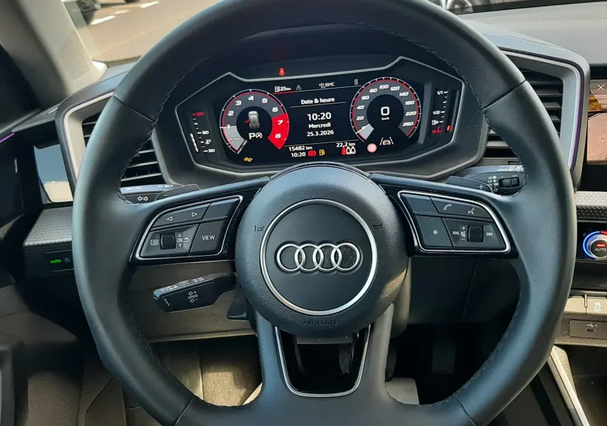 Vue rapprochée du volant cuir multifonction noir et du tableau de bord numérique de l'Audi A1 Sportback 2025.