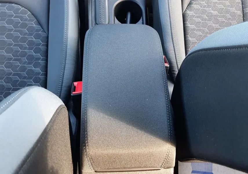 Vue plongeante sur l'accoudoir central et les sièges tissu gris noir de l'Audi A1 Sportback 2025.