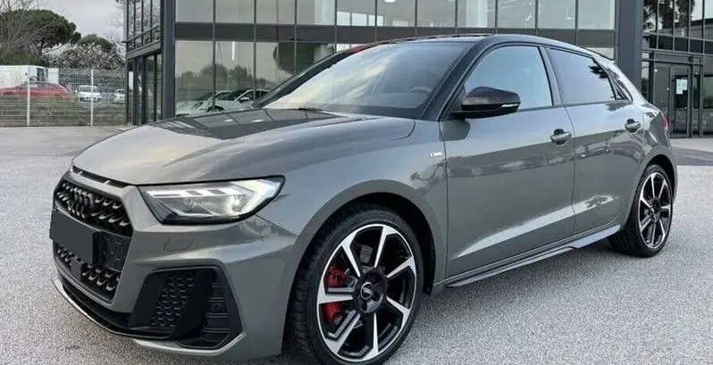 Audi A1 Sportback 30 TFSI S-Line gris Chronos avec toit noir, vue 3/4 avant droit, jantes alu 18 pouces hélice et vitres surteintées.