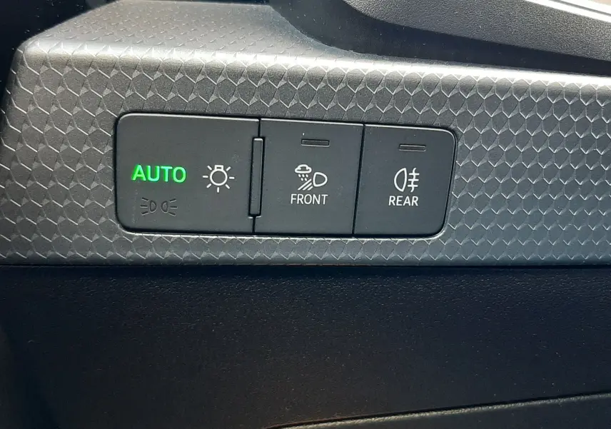 Gros plan sur les commandes d’éclairage intérieures de l’Audi A1 Sportback 2025 avec bouton auto allumé en vert.