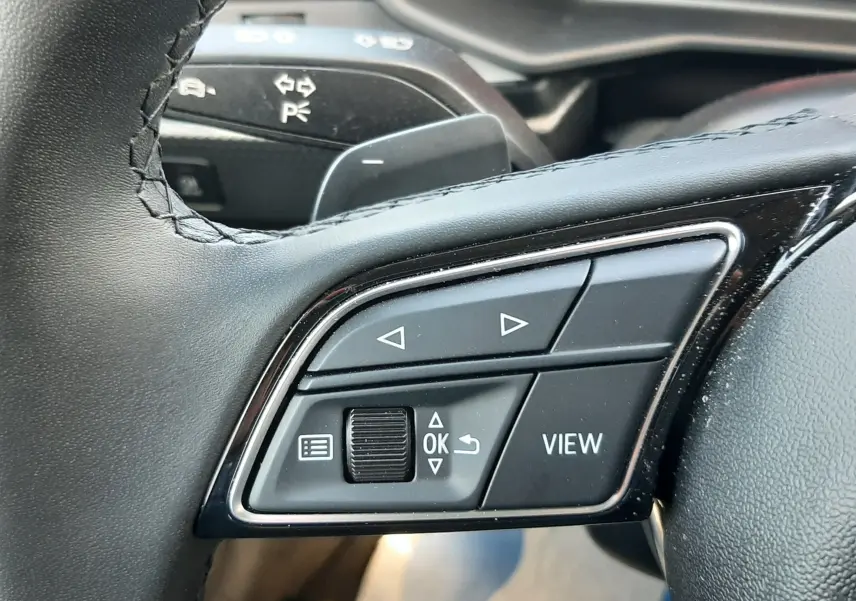 Gros plan sur les commandes multifonctions en cuir noir du volant sport de l'Audi A1 Sportback 2025.