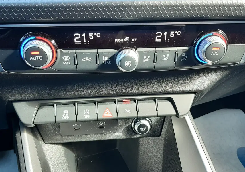 Gros plan sur la console centrale de l'Audi A1 Sportback 2025, montrant les commandes de climatisation et les boutons de fonction.