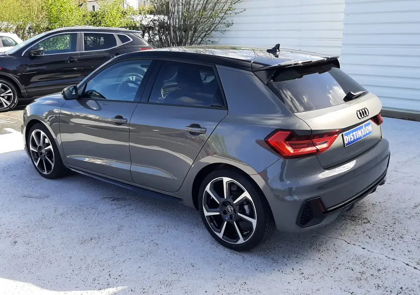 Audi A1 Sportback gris Chronos avec toit noir, vue 3/4 arrière droit, jantes alu 18 pouces et vitres surteintées.