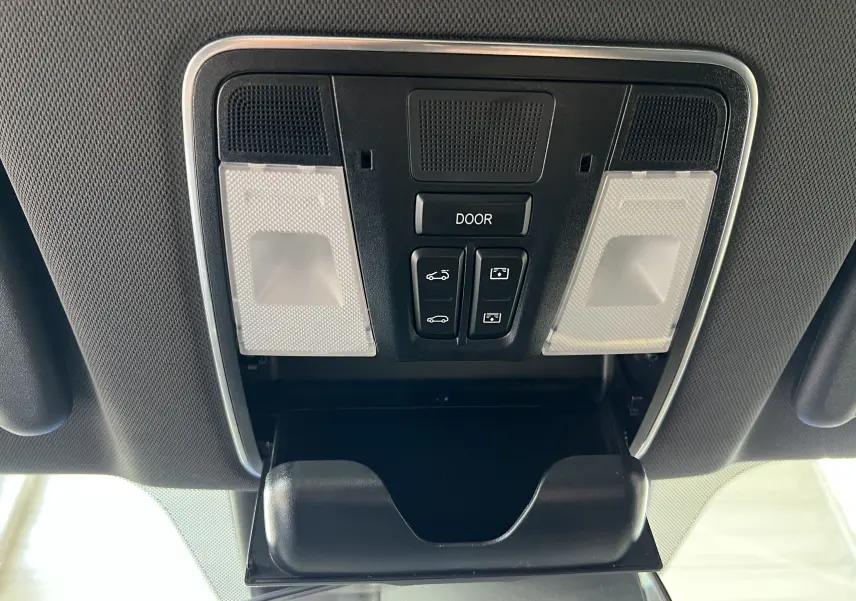 Vue en plongée du plafonnier intérieur du SERES 3 Electric 163ch Luxe avec commandes et rangement ouvert, finition noire.