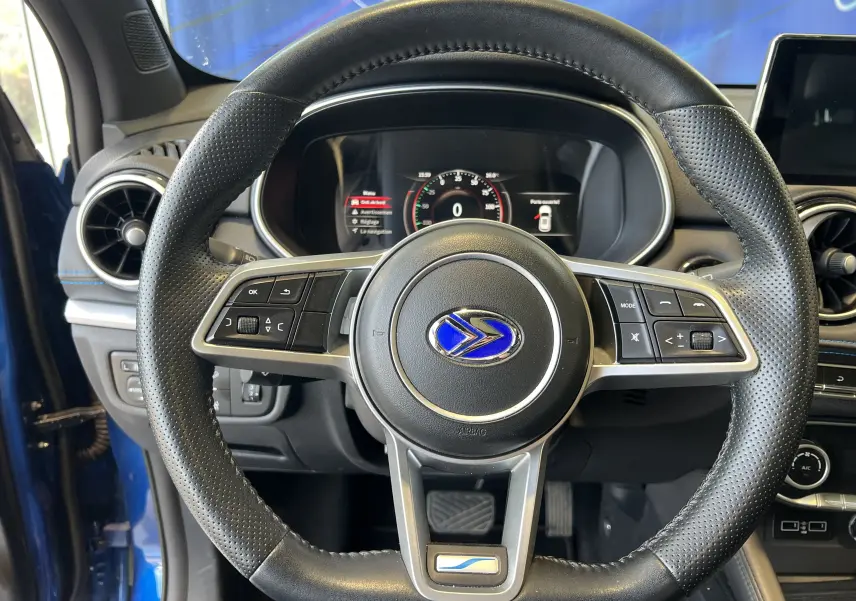 Vue centrée sur le volant noir perforé du SERES 3 Electric bleu astral avec tableau de bord digital allumé.