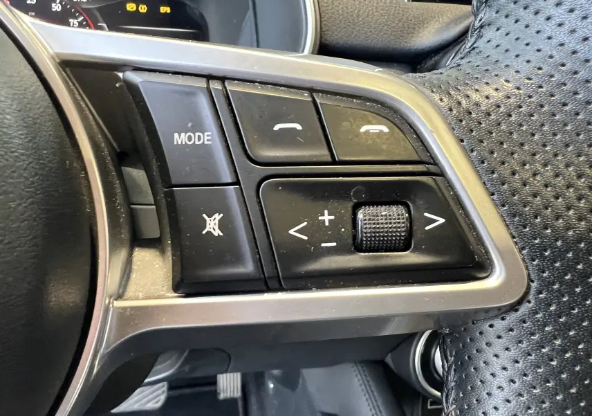 Gros plan sur les commandes du volant perforé noir du SERES 3 Electric 163ch Luxe, avec boutons mode et volume.