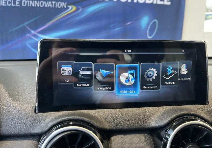 Écran tactile central du tableau de bord du SERES 3 Electric avec menu multimédia et navigation affichés.