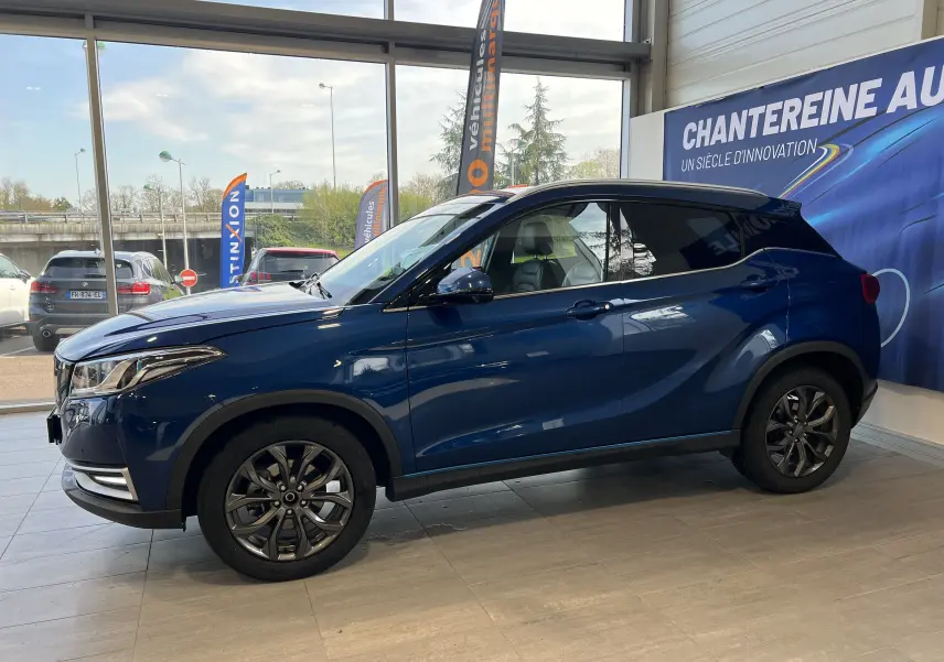 Vue de profil côté gauche d'un SUV SERES 3 Electric 163ch Luxe bleu astral métallisé en showroom.
