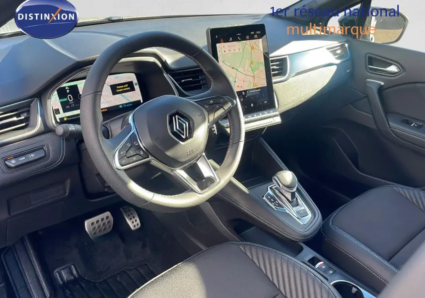 Intérieur du Renault Captur E-Tech hybride 2025, vue côté conducteur, tableau de bord moderne avec écran tactile vertical.