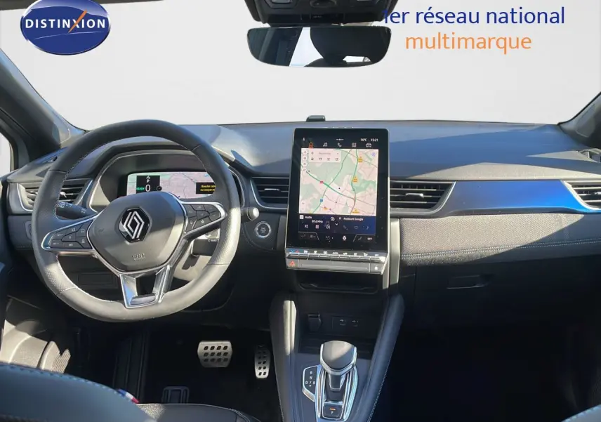 Vue intérieure du tableau de bord du Renault Captur E-Tech hybride 2025 avec écran tactile vertical et volant multifonction noir.