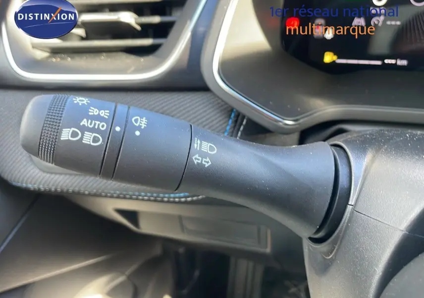 Gros plan sur la commande des feux et clignotants du tableau de bord du Renault Captur E-Tech hybride 2025.