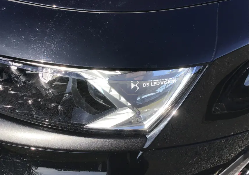 Gros plan sur le phare avant droit noir brillant du DS7 Crossback 2023 avec inscription DS LED Vision visible.