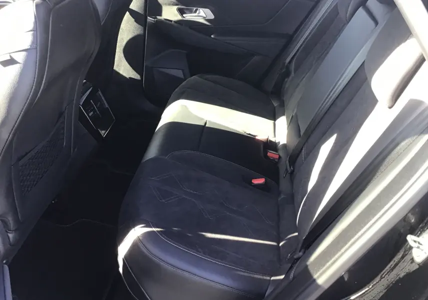 Vue intérieure côté droit des sièges arrière en cuir noir et alcantara du DS7 Crossback 2023, avec ceinture et porte ouvert.