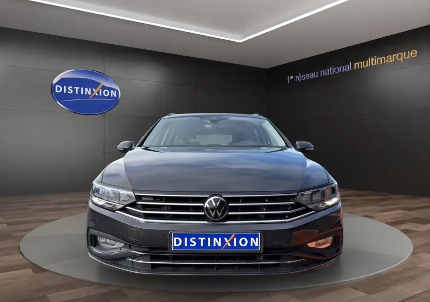 Vue frontale d'une Volkswagen Passat SW gris manganèse 2022 avec calandre chromée et logo VW visible.