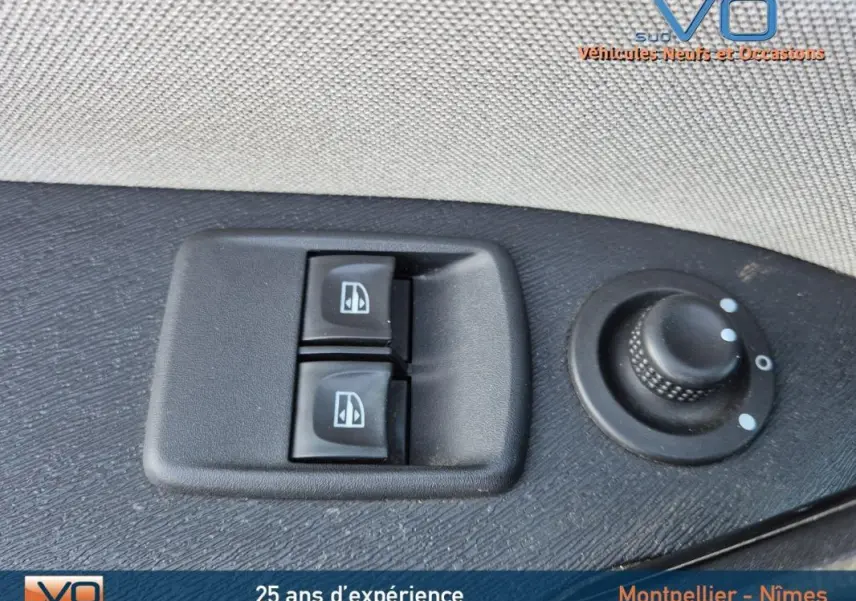 Gros plan sur les commandes électriques des vitres et réglage des rétroviseurs côté conducteur du Renault Kangoo blanc 2016.