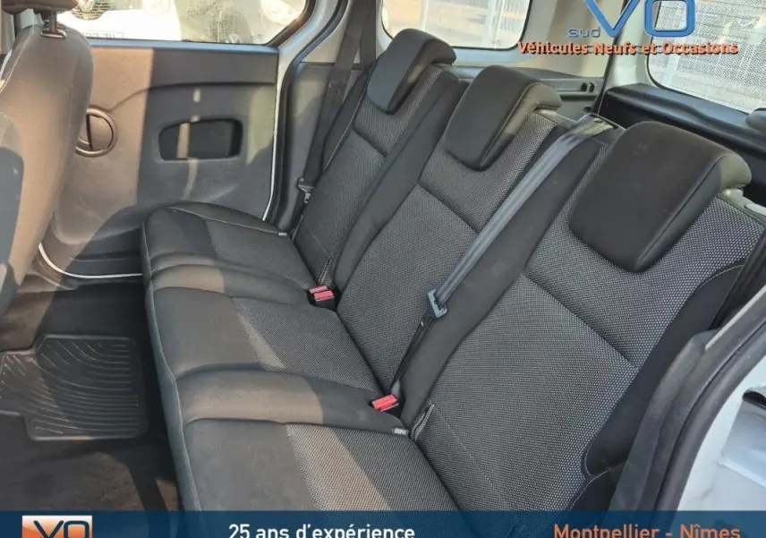 Vue intérieure côté droit du Renault Kangoo blanc 2016, montrant la banquette arrière en tissu noir.