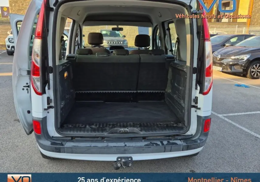 Vue arrière ouverte du Renault Kangoo blanc 2016 montrant le grand espace de chargement vide et les sièges arrière.