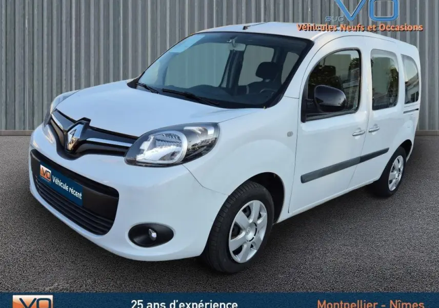 Renault Kangoo blanc en 3/4 avant droit, avec porte latérale et vitres surteintées visibles.