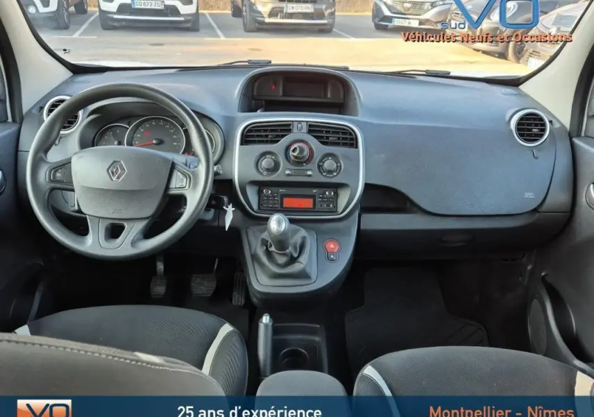Vue intérieure du tableau de bord et volant du Renault Kangoo blanc 2016 avec boîte manuelle et commandes centrales visibles