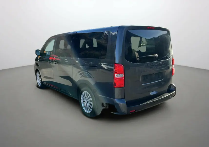 Vue 3/4 arrière droite d'un Peugeot Traveller gris titane avec vitres surteintées et jantes tôle 17 pouces.