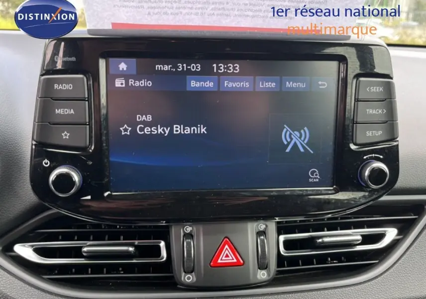 Vue rapprochée de l’écran multimédia central noir brillant de la Hyundai i30 SW 2023 avec commandes tactiles et boutons physiques.