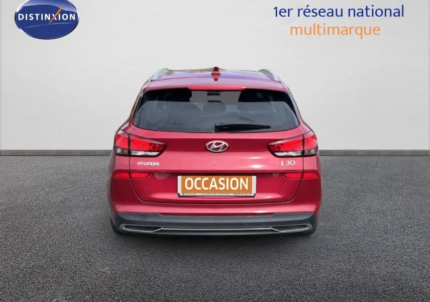 Vue arrière d'une Hyundai i30 SW 2023 en rouge Sunset Red Metal avec plaque "OCCASION" visible.