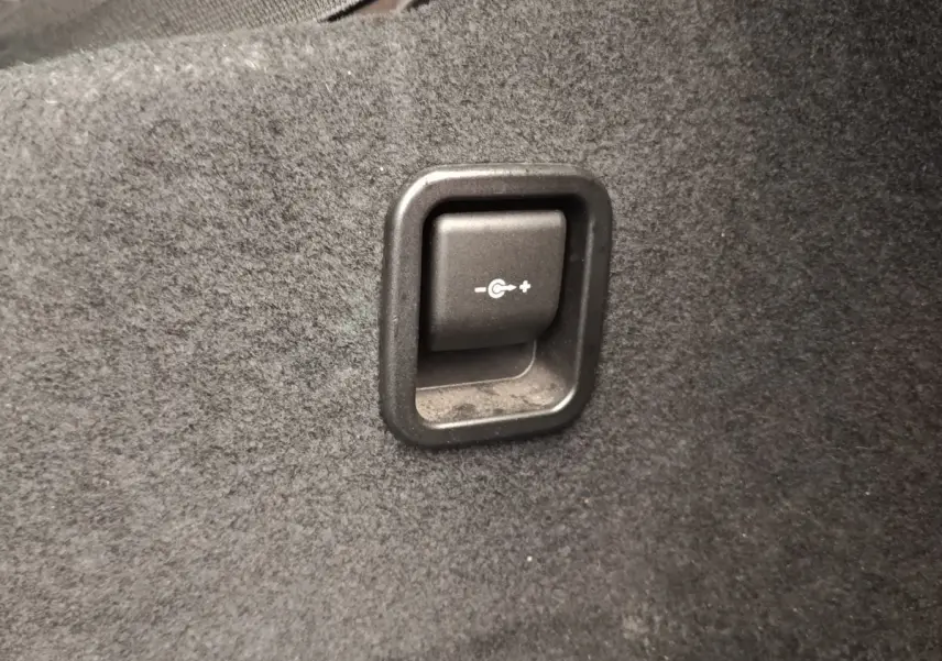 Gros plan sur le bouton de réglage de la récupération d'énergie dans le coffre gris foncé d'une BMW Série 2 Gran Tourer F46.