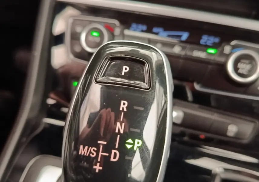Gros plan sur le levier de vitesses automatique noir brillant de la BMW Série 2 Gran Tourer 218i Lounge 2022, intérieur moderne.