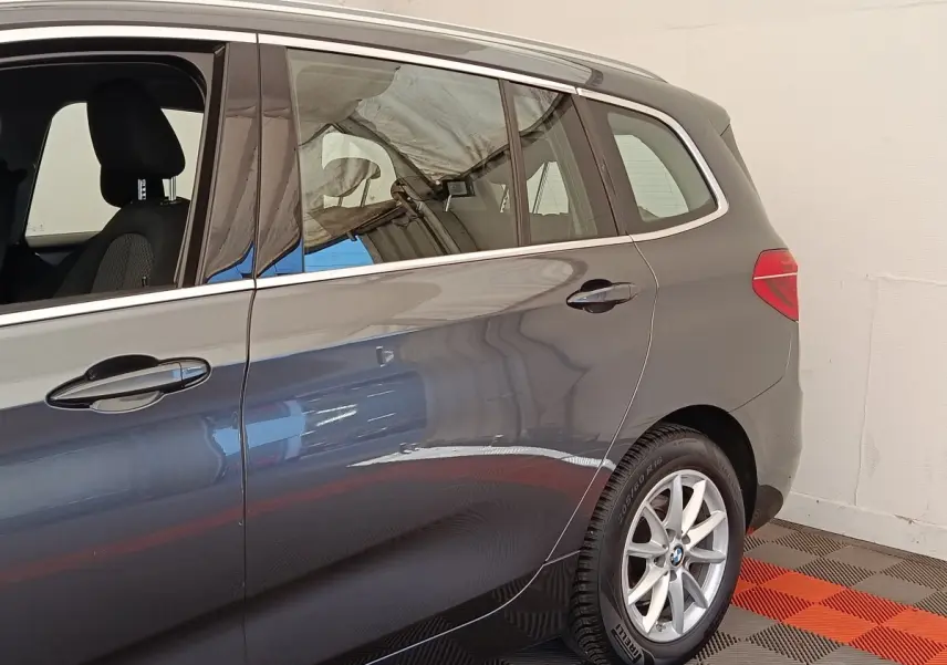 Vue côté droit arrière d'une BMW Série 2 Gran Tourer F46 gris clair avec jantes alliage et vitres teintées.