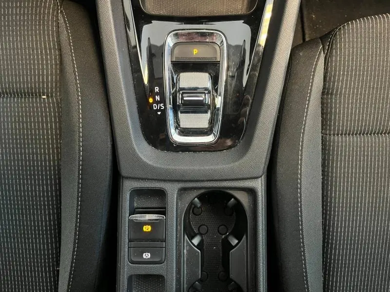 Vue rapprochée de la console centrale noire avec levier de vitesse automatique et sièges tissu noir à surpiqûres blanches dans Skoda Octavia Combi.