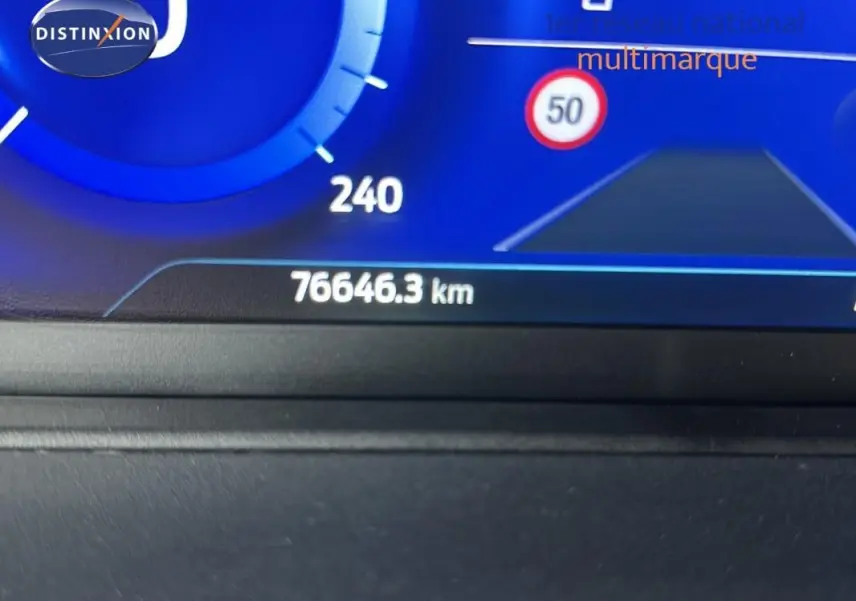 Compteur digital affichant 76 646 km et panneau de limitation à 50 km/h sur Ford Puma rouge 3/4 avant.