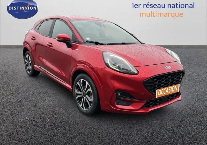 Ford Puma rouge vue 3/4 avant droit avec jantes alliage 17 pouces et calandre noire en arrière-plan neutre.