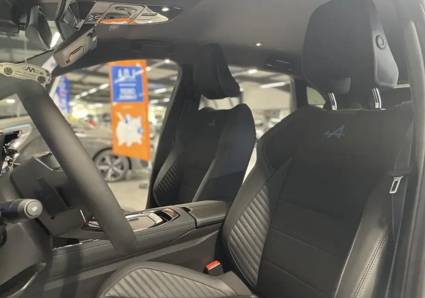 Intérieur du Renault Austral Esprit Alpine 2025, vue côté conducteur sur sièges noirs en Alcantara avec logo Alpine bleu.