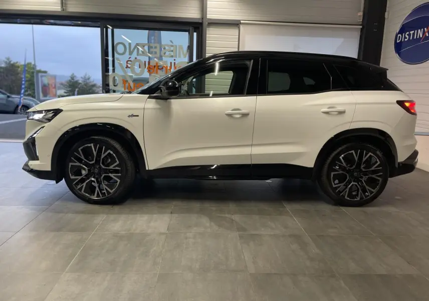 Profil droit du Renault Austral 2025 blanc nacré satin avec toit noir et jantes alliage noires diamantées.