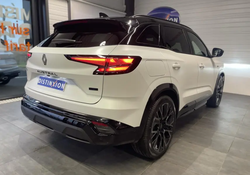 Vue 3/4 arrière droite du Renault Austral blanc nacré avec toit noir et jantes alliage noires satinées.