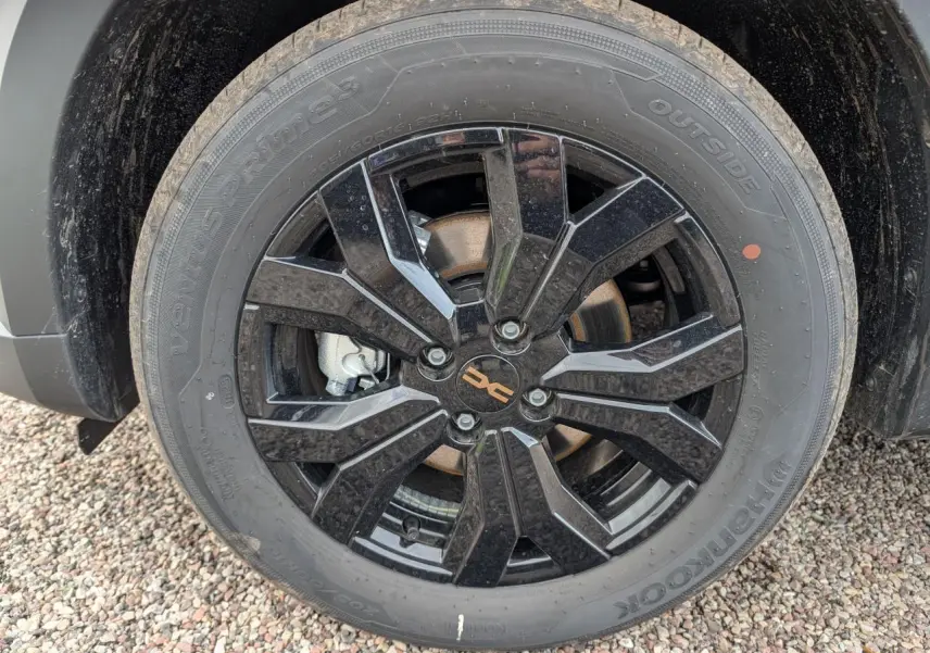 Gros plan sur la jante aluminium noire 16 pouces Mahalia du Dacia Jogger vert métallisé, avec pneu Hankook.