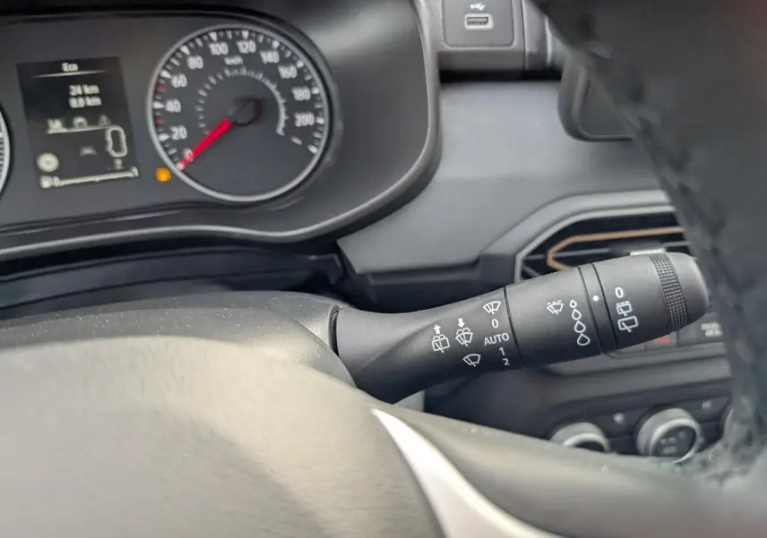 Vue intérieure rapprochée du commodo d’essuie-glace et du tableau de bord gris d’un Dacia Jogger 2025.