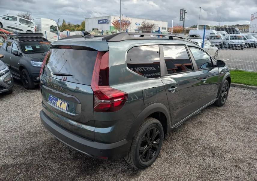 Vue 3/4 arrière droite du Dacia Jogger 2025 vert métallisé avec vitres teintées et jantes noires.