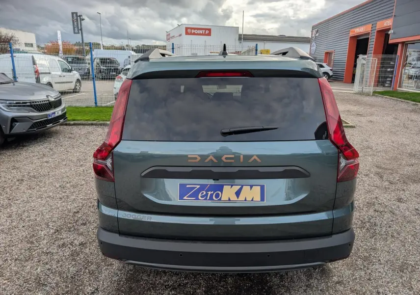 Vue arrière d'un Dacia Jogger vert métallisé avec logo brun cuivré et feux arrière verticaux distinctifs.