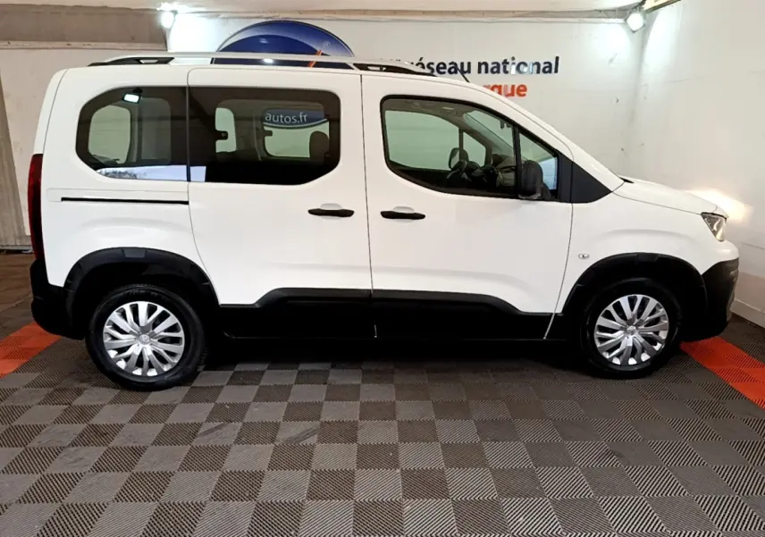 Peugeot Rifter blanc vue de profil côté gauche, avec rails de toit chromés et jantes acier à enjoliveurs.