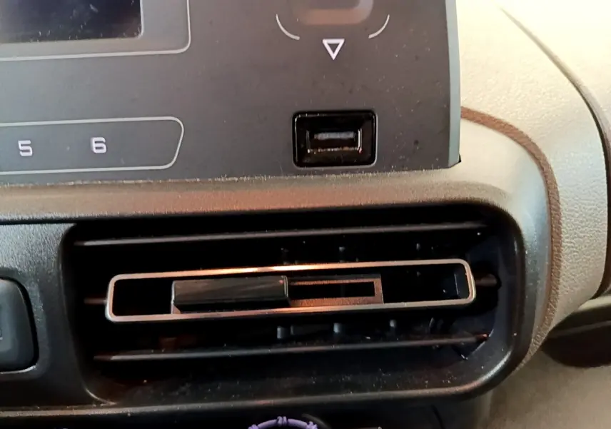 Gros plan sur la sortie d’air centrale du tableau de bord du Peugeot Rifter blanc, version PureTech 110 S&S Active.