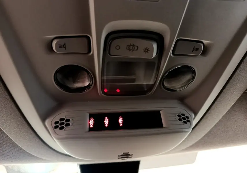 Vue en contre-plongée du plafonnier gris avec commandes d’éclairage et indicateurs de ceinture du Peugeot Rifter blanc 2019.
